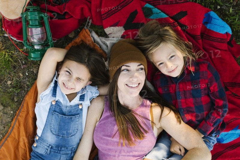 Portrait of woman with son (6-7) and daughter (8-9) lying on blanket