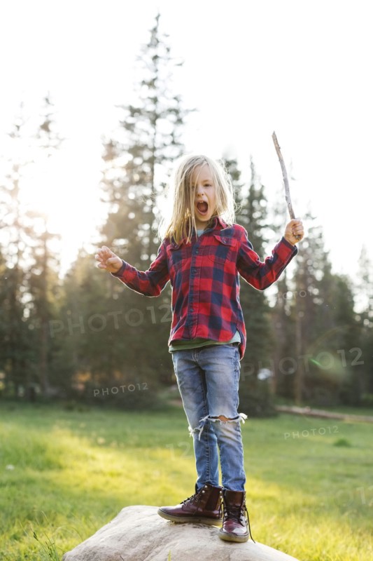 Portrait of boy (6-7) standing on rock in forest
