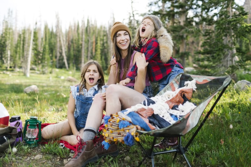 Mother with son (6-7) and daughter (8-9) camping in forest