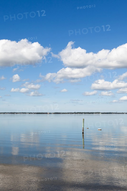 Clouds reflecting in water on sunny day