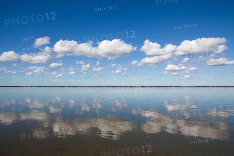 Clouds reflecting in water on sunny day