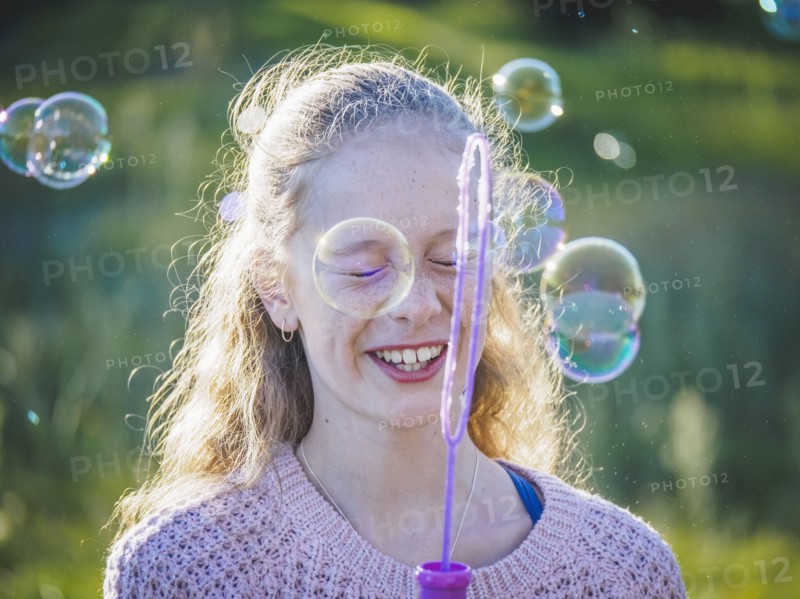 Girl (12-13) blowing bubbles