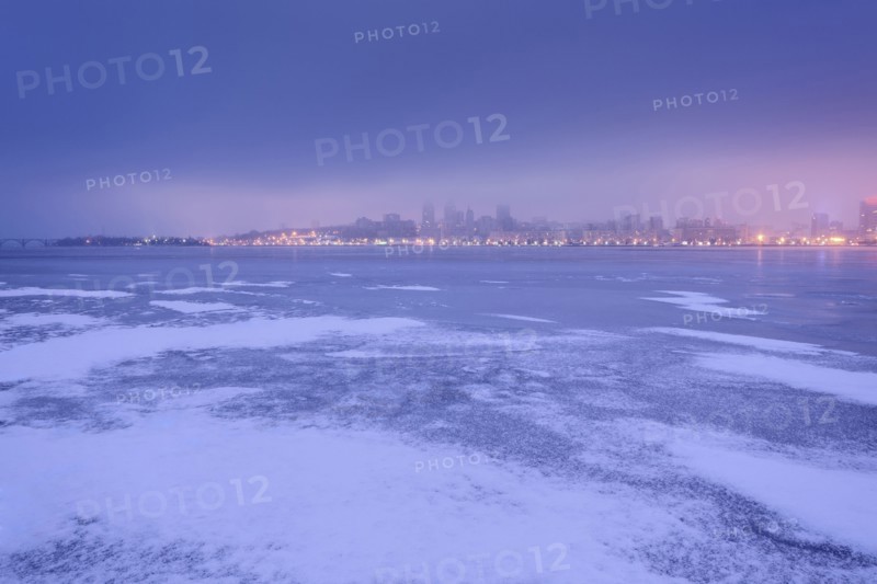 Ukraine, Dnepropetrovsk region, Dnepropetrovsk city, Dramatic sky over frozen river at dusk