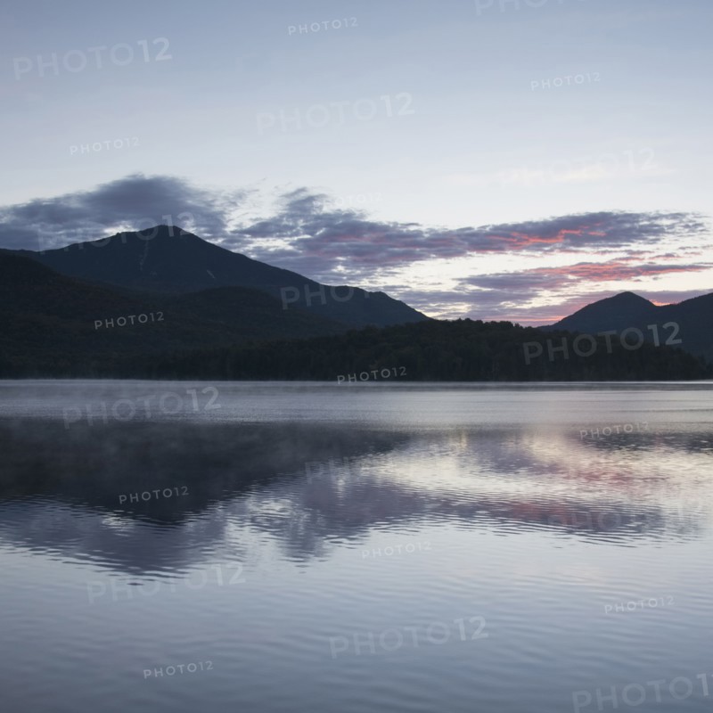 USA, New York, Lake Placid, Mountain and clouds reflecting in lake