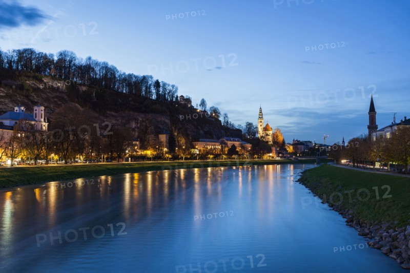 Austria, Salzburg, River and illuminated riverbank at dusk