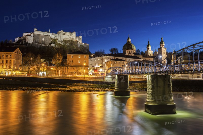 Austria, Salzburg, Riverbank with buildings at night