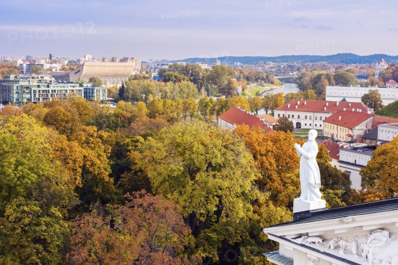 Lithuania, Vilnius, Statue on roof with cityscape in background