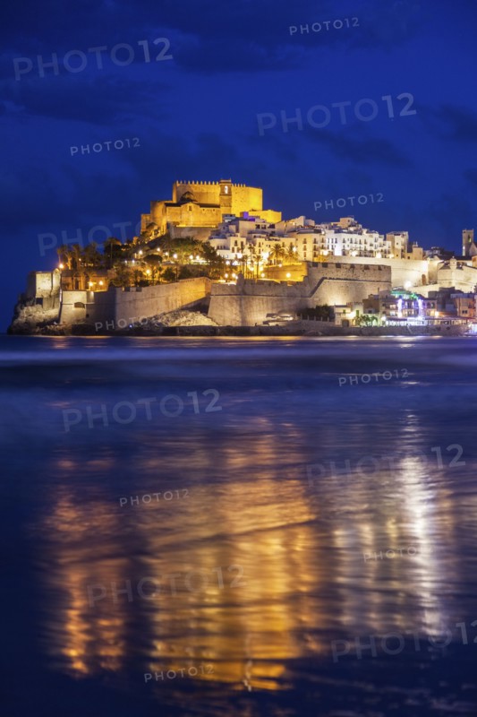 Spain, Valencian Community, Peniscola, Town with fortified wall by sea at dusk