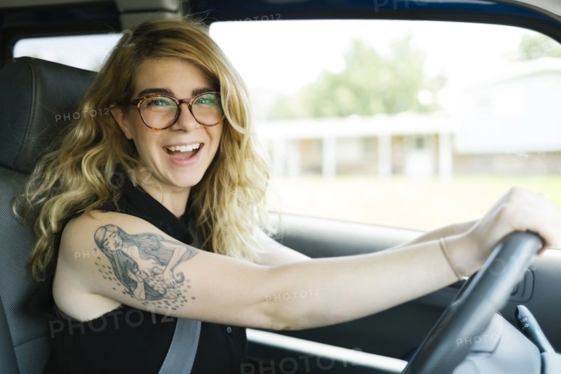 Woman driving car and laughing