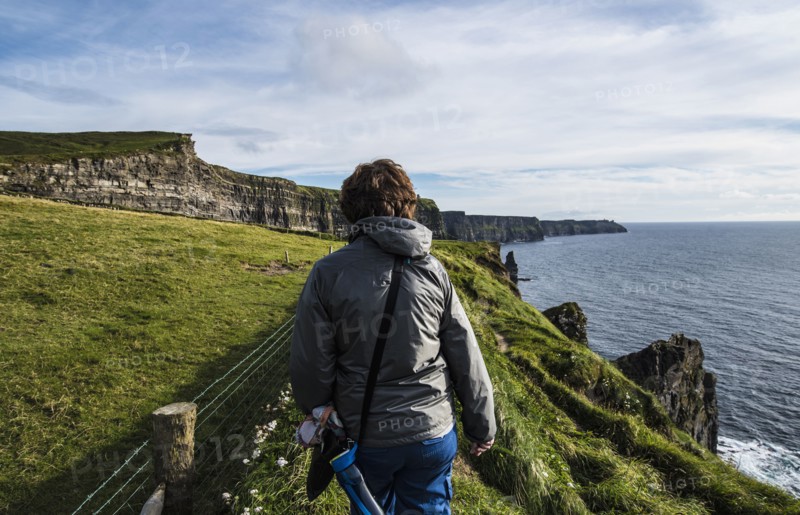 Ireland, County Clare, Woman walking along Cliffs of Moher