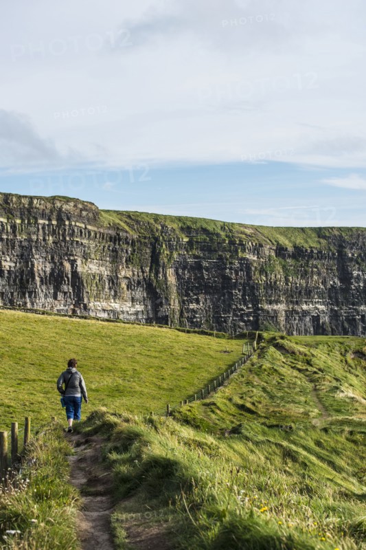 Ireland, Clare County, Woman walking along Cliffs of Moher