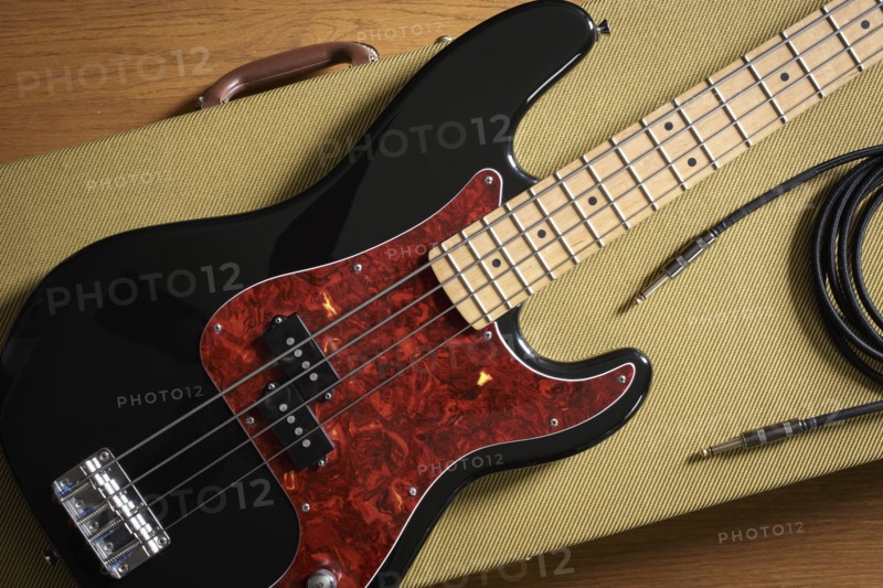 Bass guitar and cable lying on guitar case