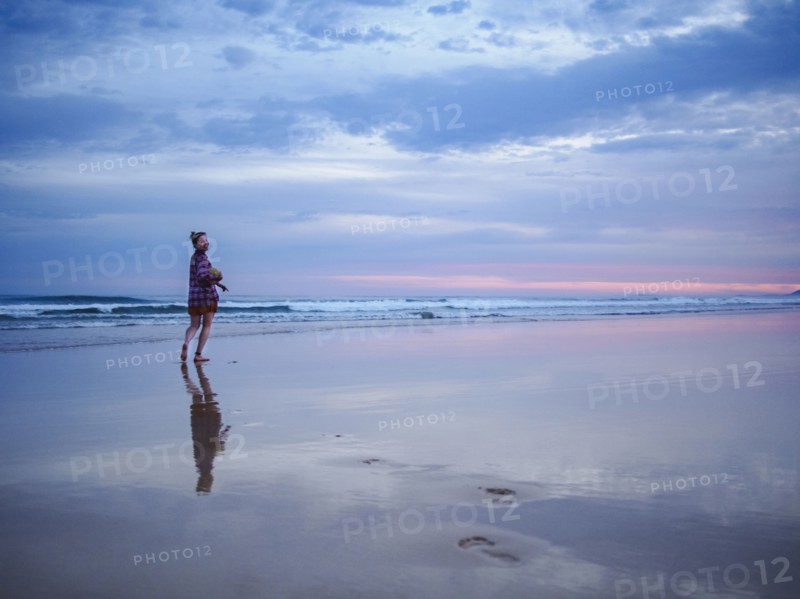 Australia, New South Wales, Woman standing on beach at dusk