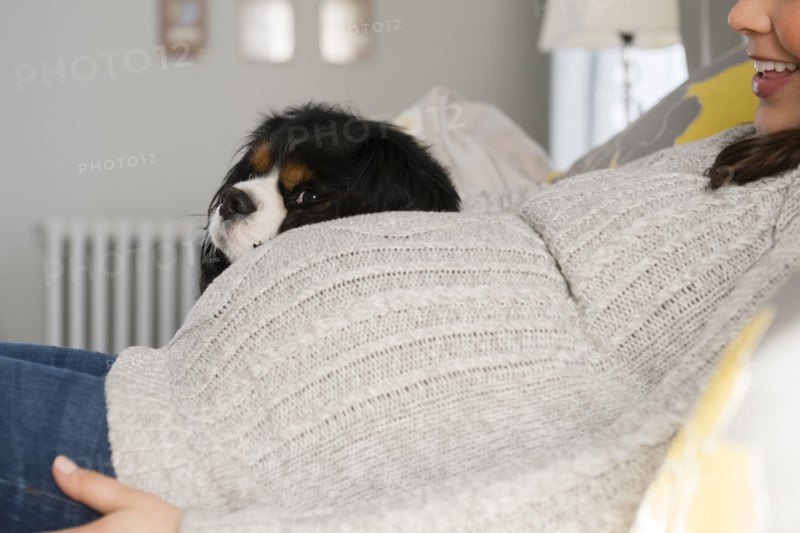Side view of pregnant woman relaxing next to dog
