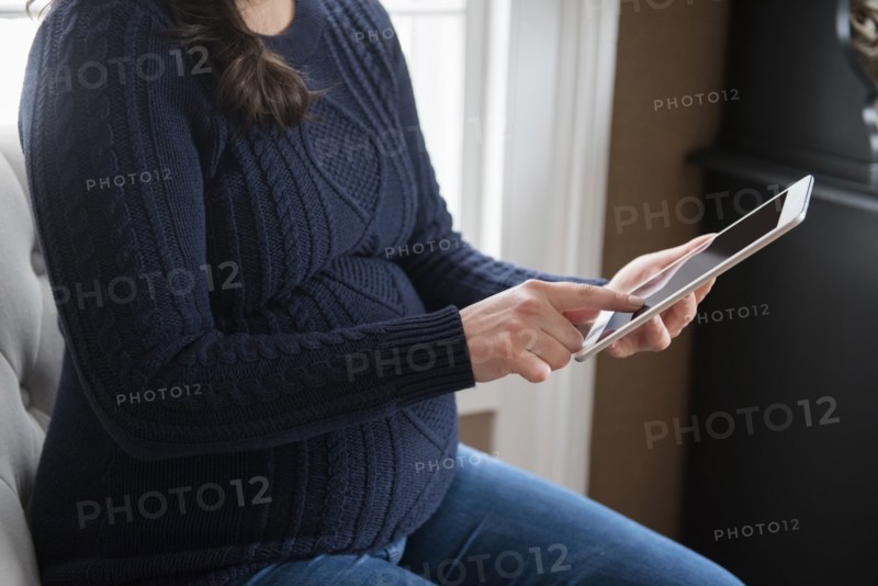 Pregnant woman using digital tablet