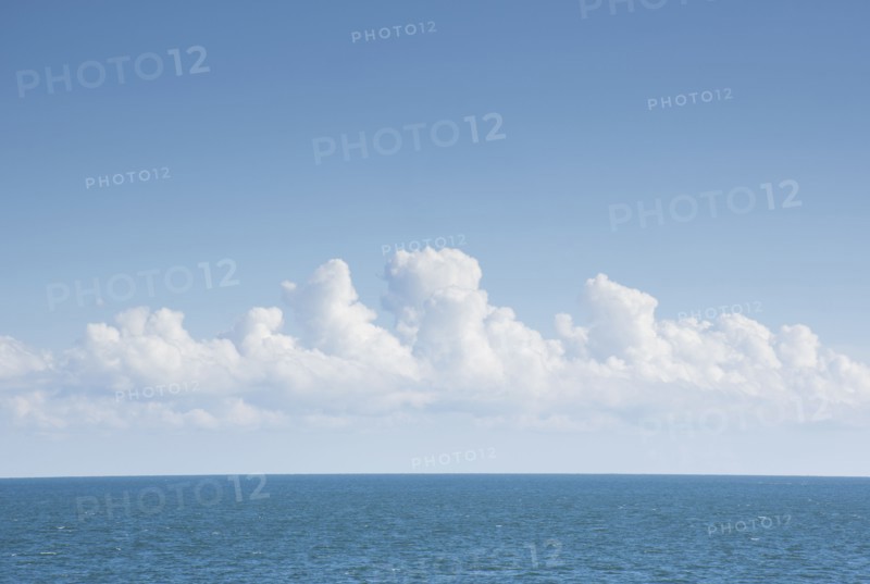 White cumulus clouds above blue Atlantic Ocean