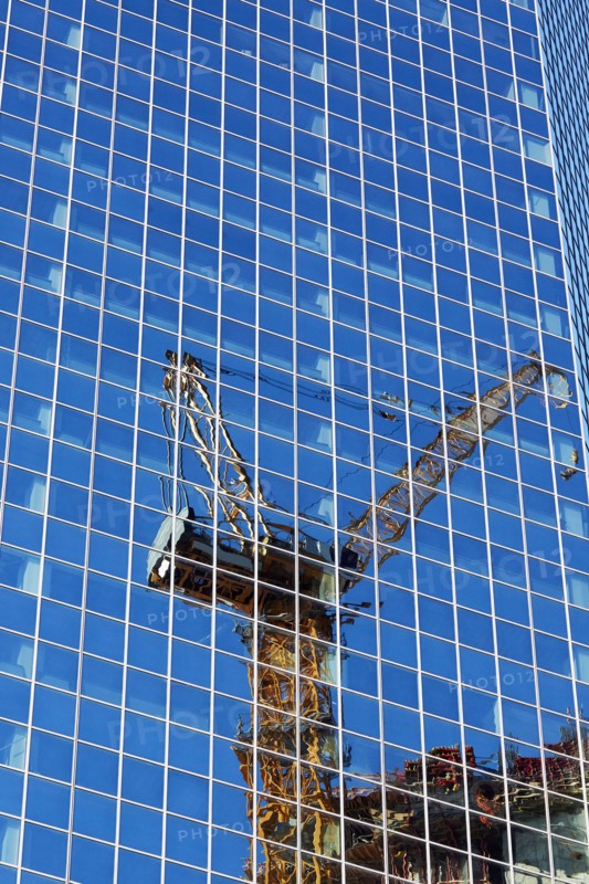 USA, New York, New York City, Crane reflecting in glass wall