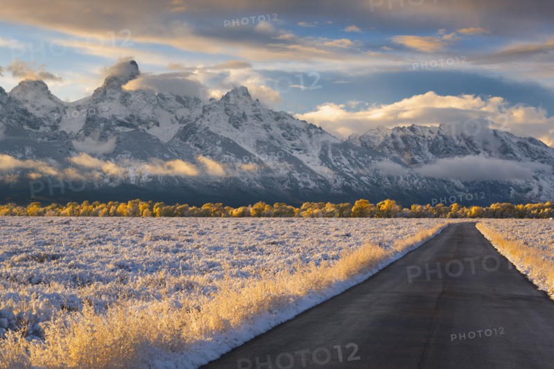 USA, Wyoming, Country road and Teton Range at sunset