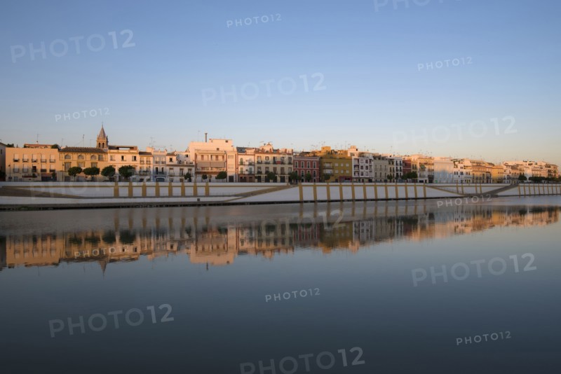 Spain, Seville, Colorful residential building reflecting in Guadalquivir river