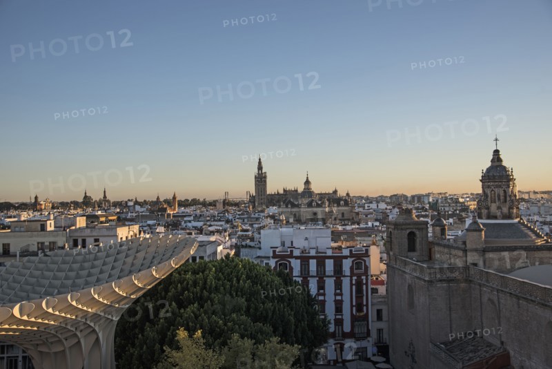 Spain, Andalusia, Seville, Cityscape in sunlight at dusk seen from Metropol Parasol in Plaza de Encarnacion