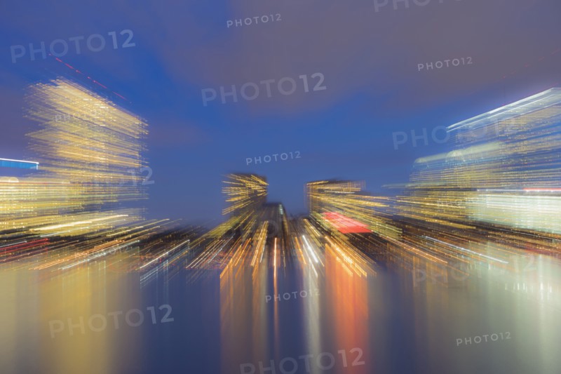 Light trails from city skyline at dusk