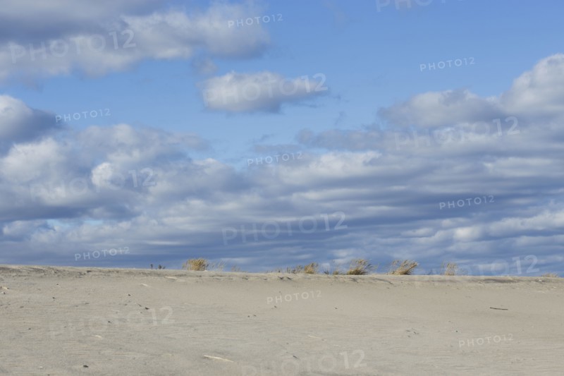 Clouds over sand dunes on beach