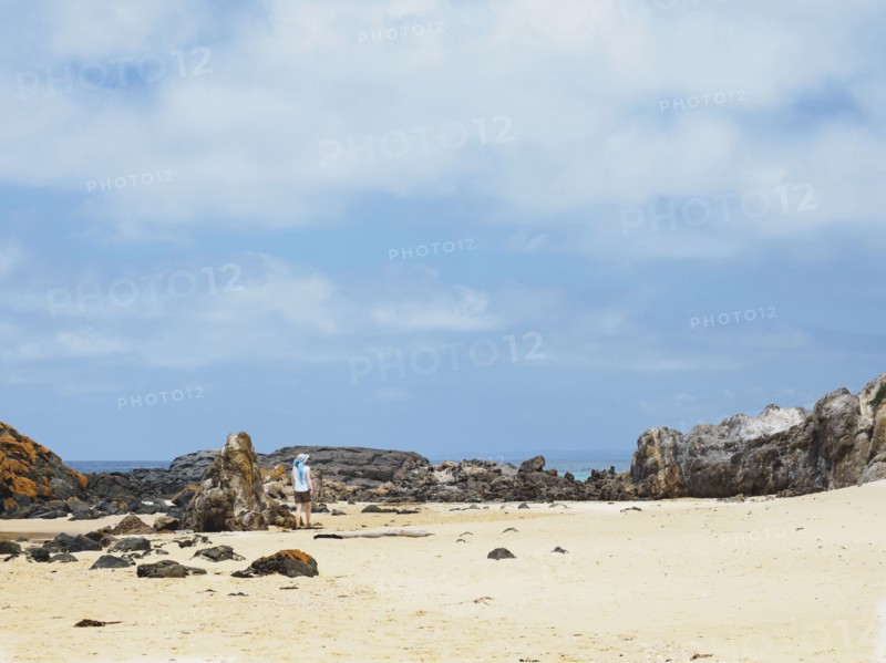 Australia, New South Wales, Bermagui, Woman walking along sandy beach