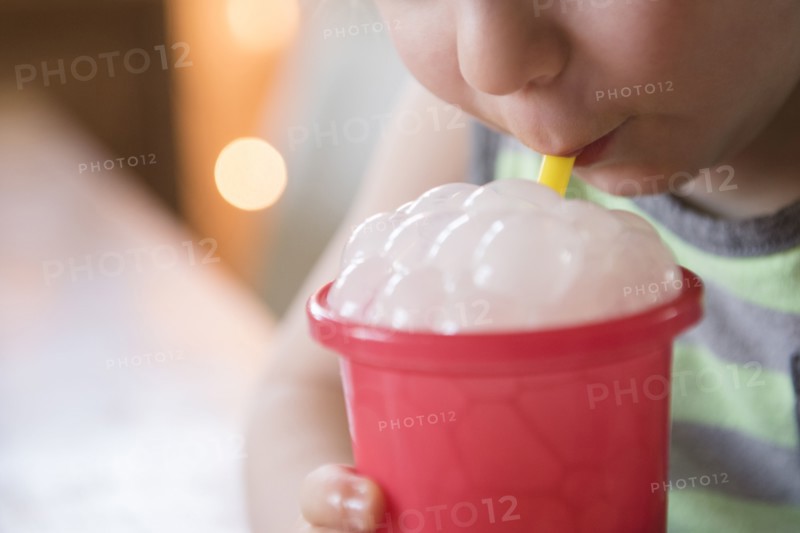 Boy blowing bubbles in drink