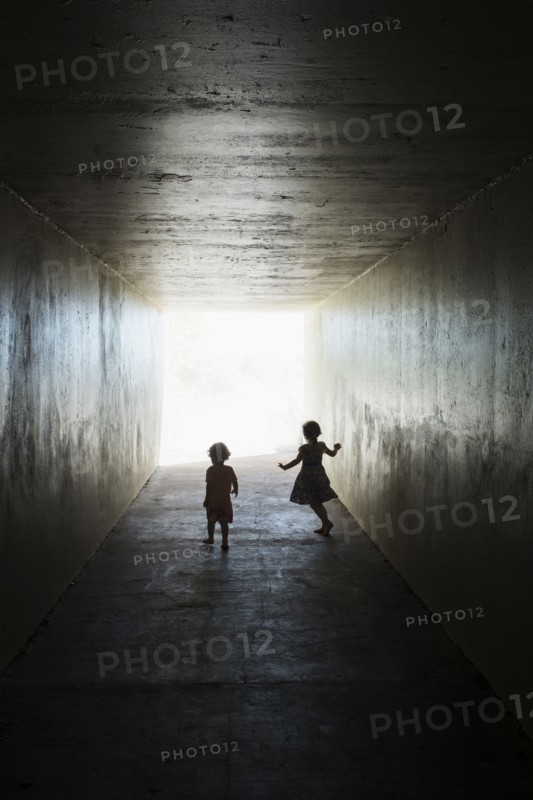 Silhouettes of children in tunnel