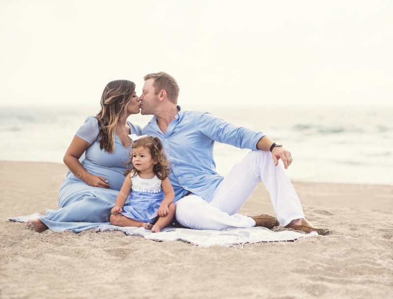 Family sitting on blanket on beach
