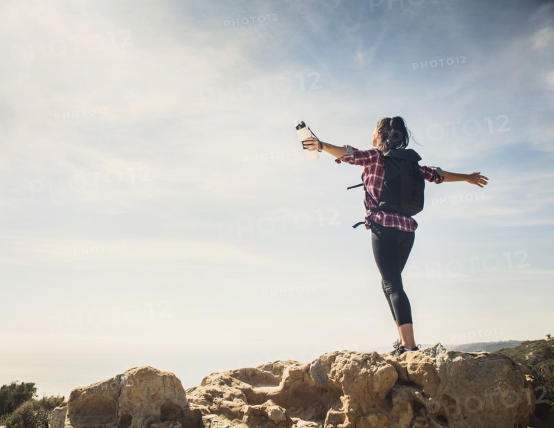 Woman on hike with arms outstretched