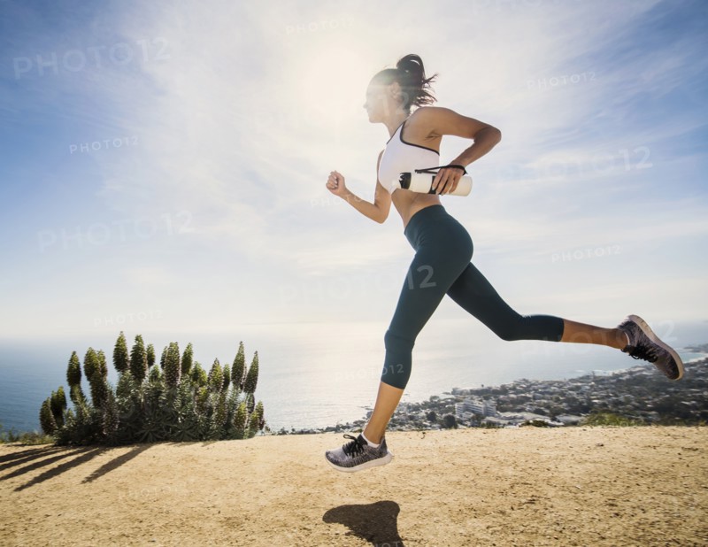 Woman jogging on mountain with water bottle