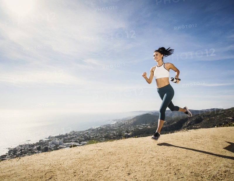 Woman jogging on mountain with water bottle