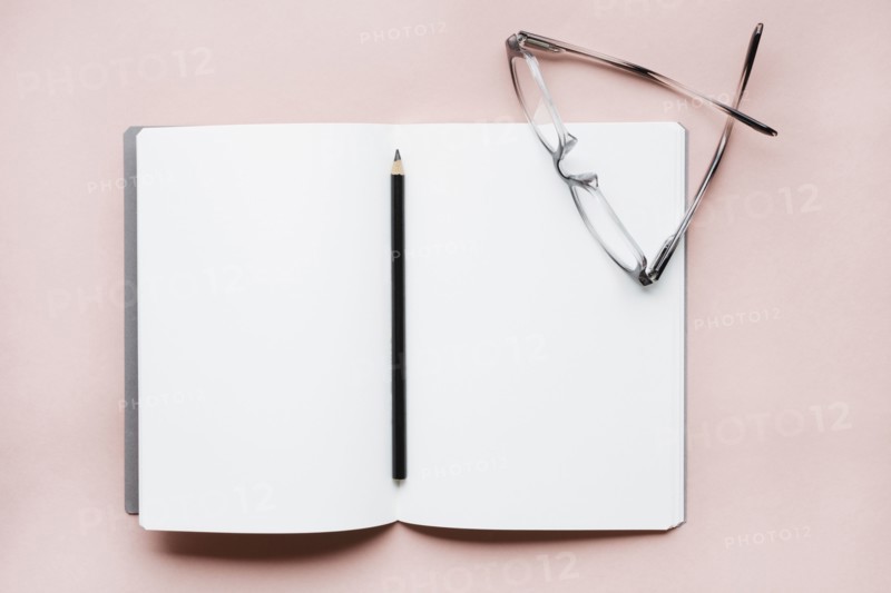 Pencil and glasses on open notebook