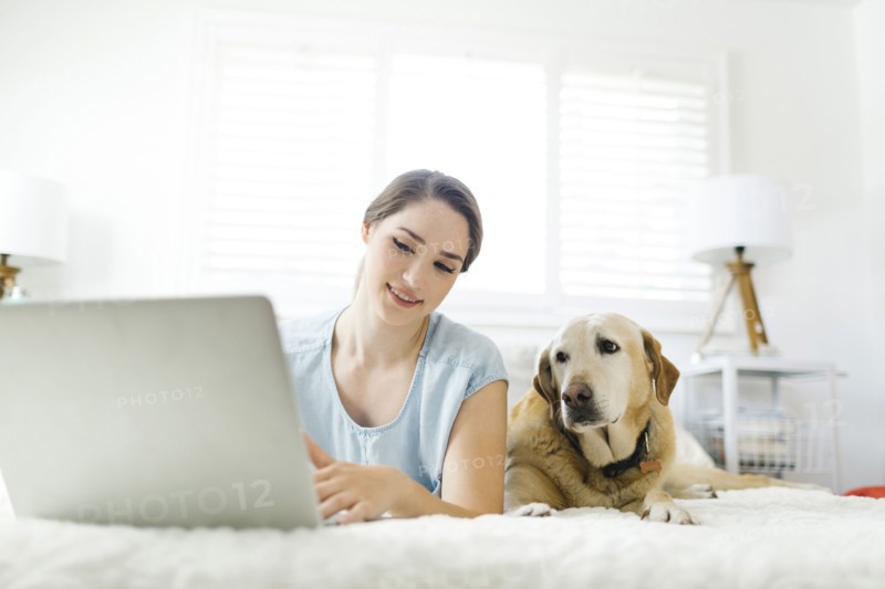 Woman using laptop with dog