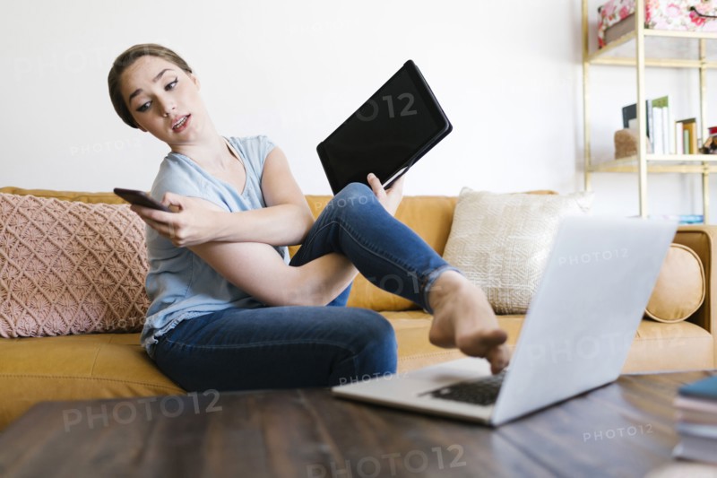 Woman holding smart phone and folder while typing with foot