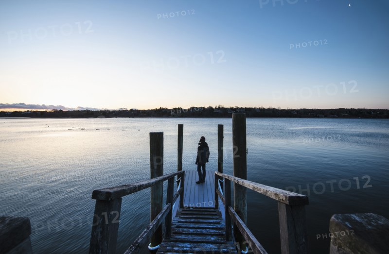 Man standing on pier at dawn