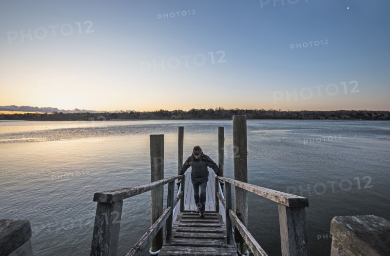 Man standing on pier at dawn