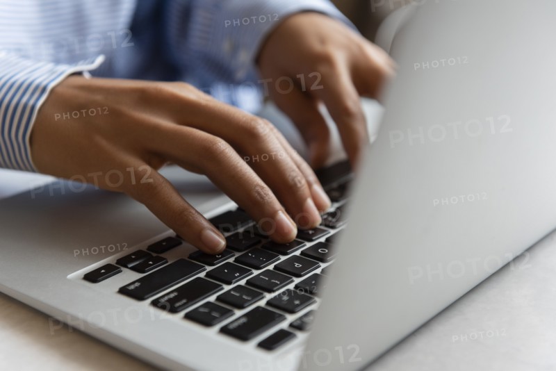 Hands of woman typing on laptop
