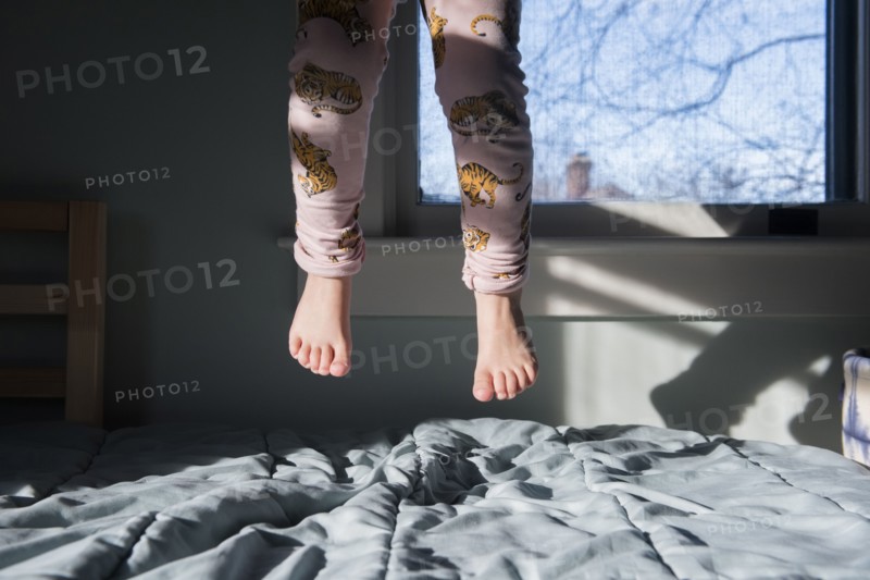 Legs of girl jumping on bed