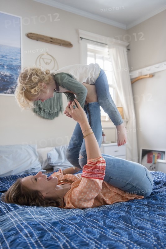 Woman playing with her son on bed