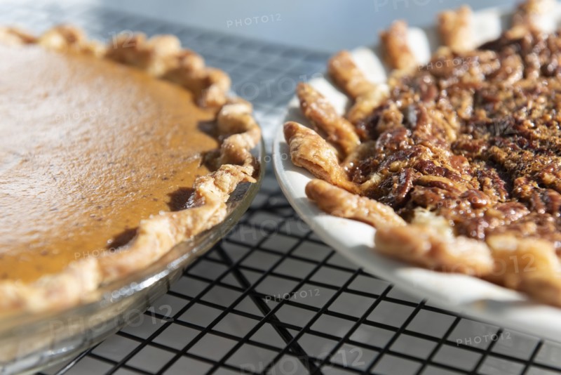 Pumpkin and pecan pies on a cooling rack