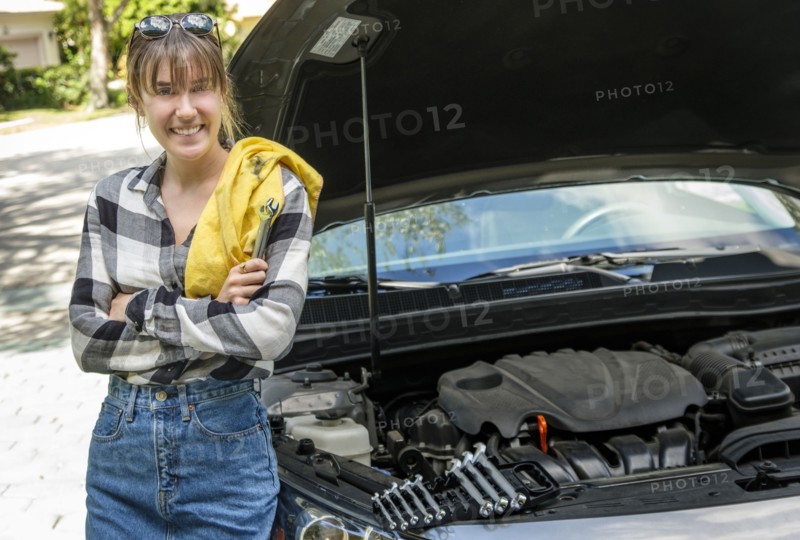 Woman with oil rag beside car