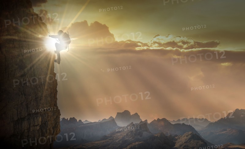 Silhouette of woman rock climbing in the Dolomites at sunrise