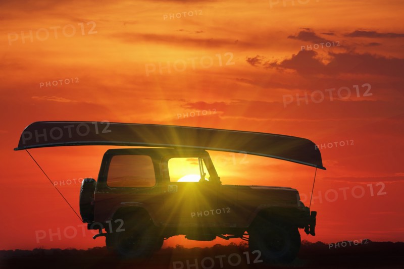 Canoe on top of Jeep at sunset