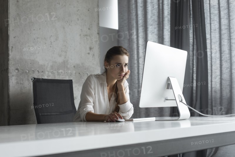Frustrated businesswoman working at desktop computer