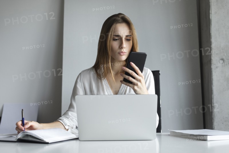 Young businesswoman looking at smartphone