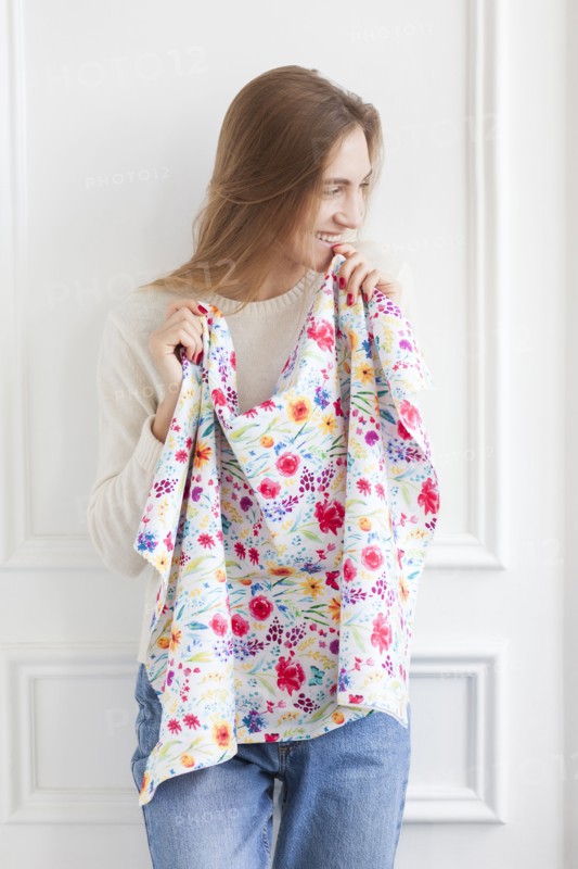 Smiling woman holding floral pattern fabric