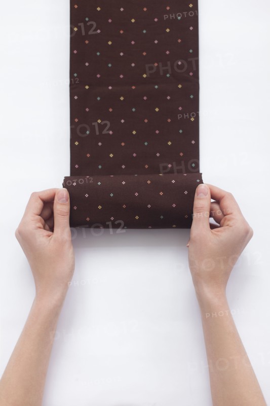 Hands of woman folding brown fabric