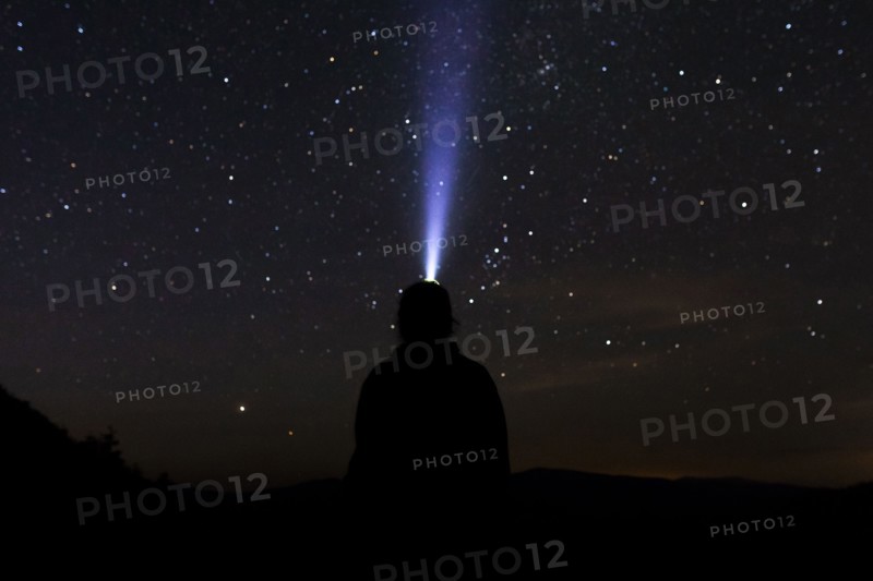 Silhouette of man with headlamp at night